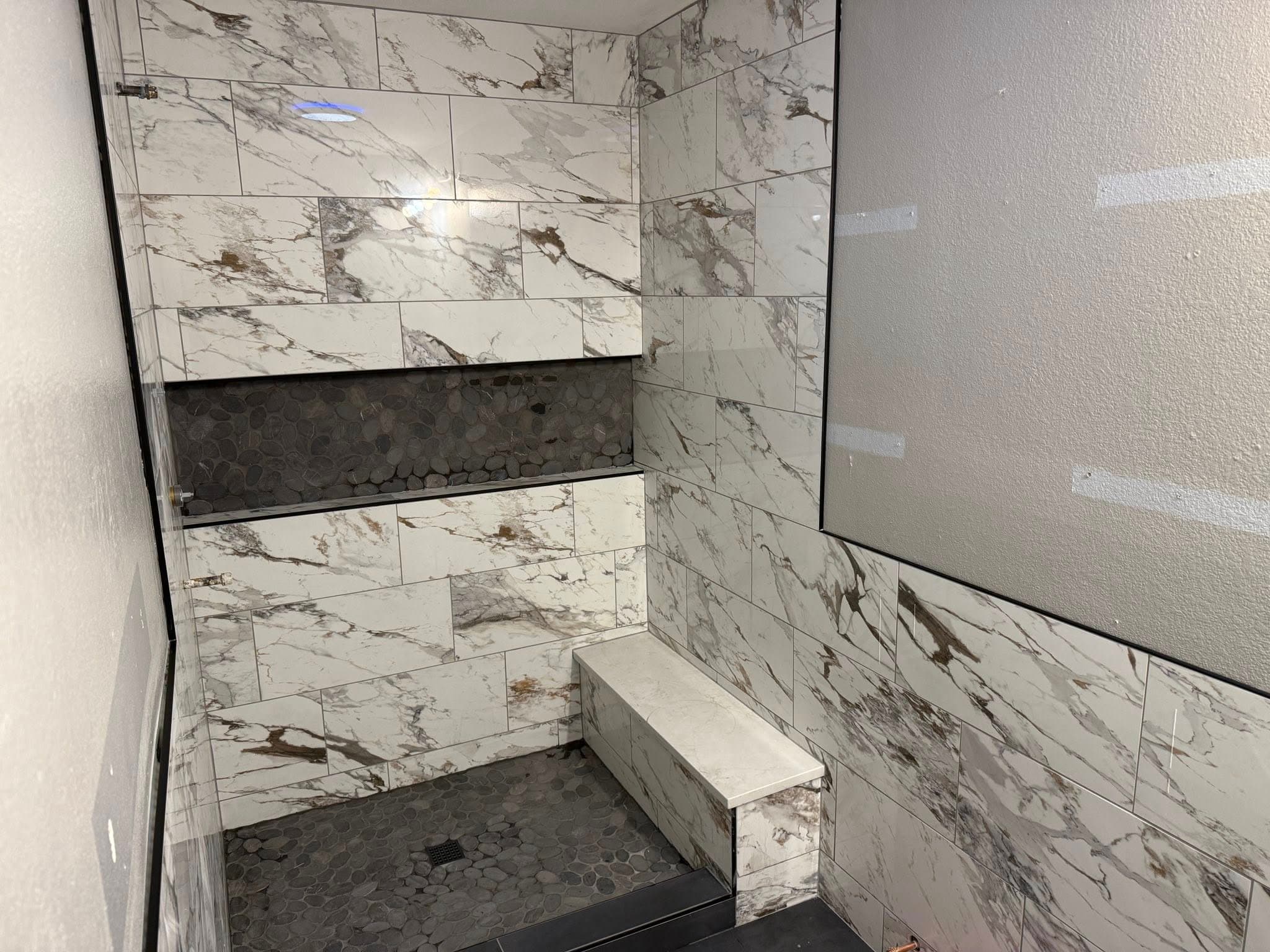Calacatta marble shower with floating bench