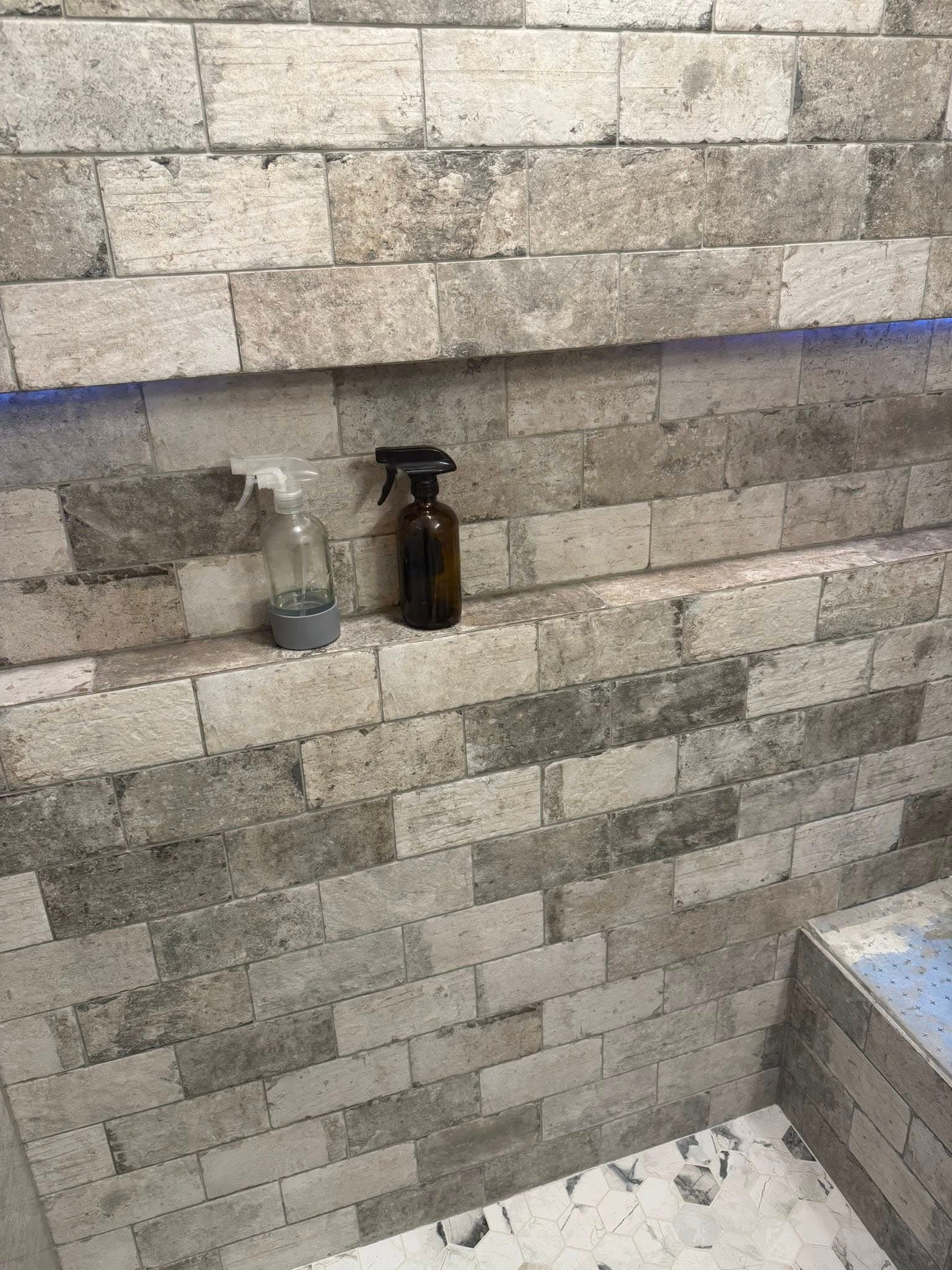 Gray brick shower wall with floating niche